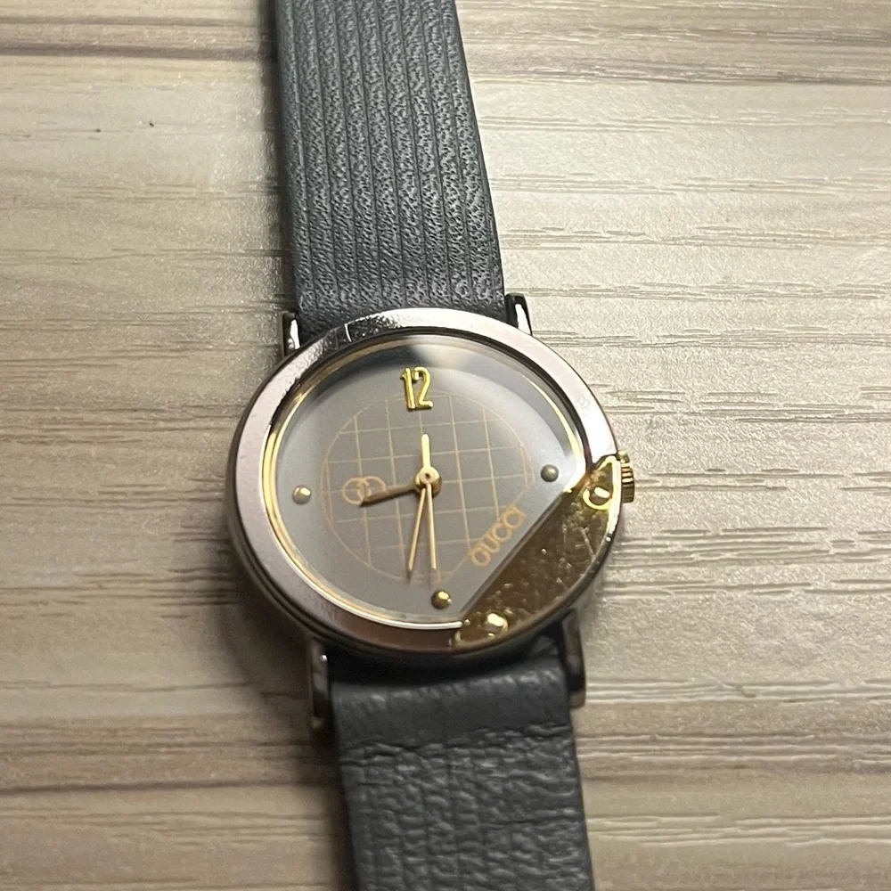 Gucci branded watch with grey leather strap and gold details